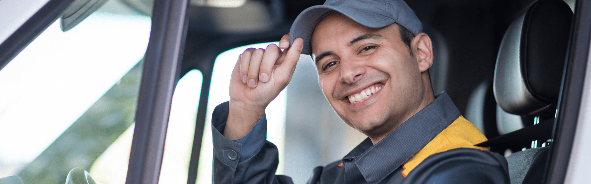 final mile driver smiling and tipping hat from behind the wheel
