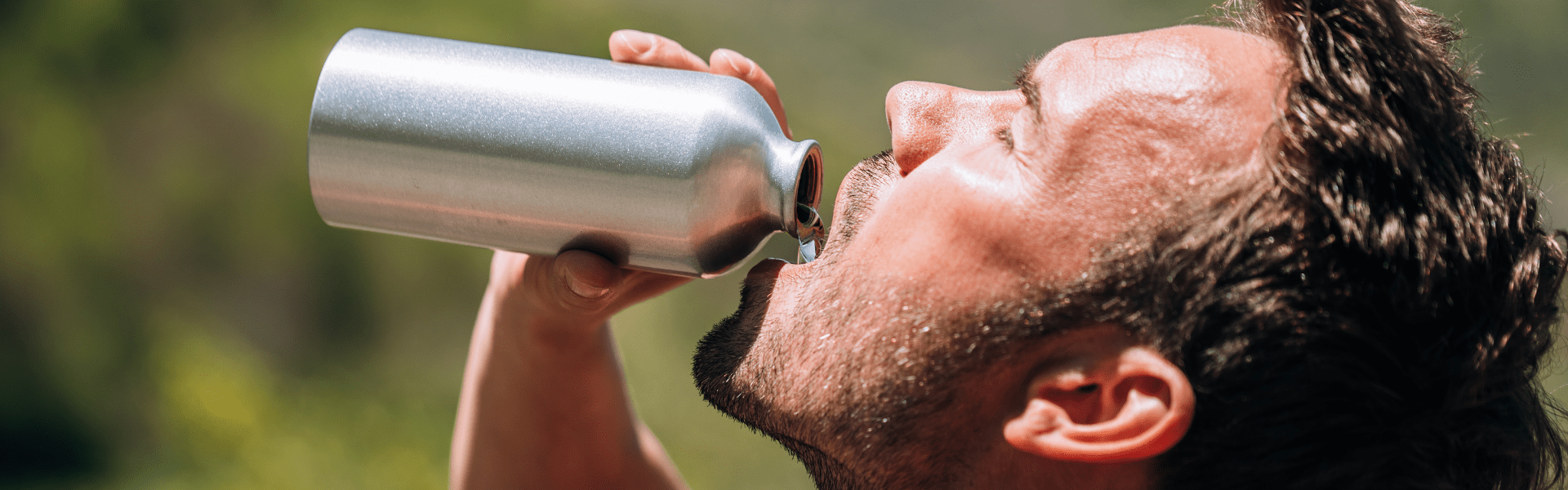 man drinking water from stainless steel water bottle