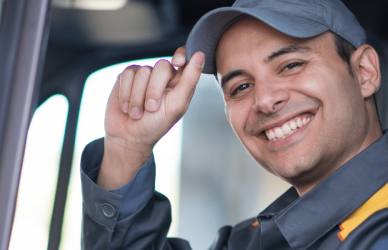 final mile driver smiling and tipping hat from behind the wheel