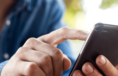 man holding phone and touching screen with other hand
