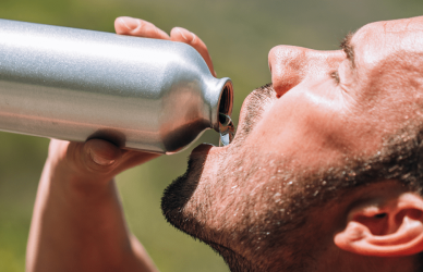 man drinking water from stainless steel water bottle